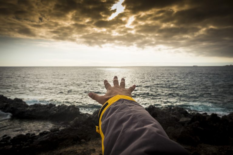 image of a man reaching for the horizon